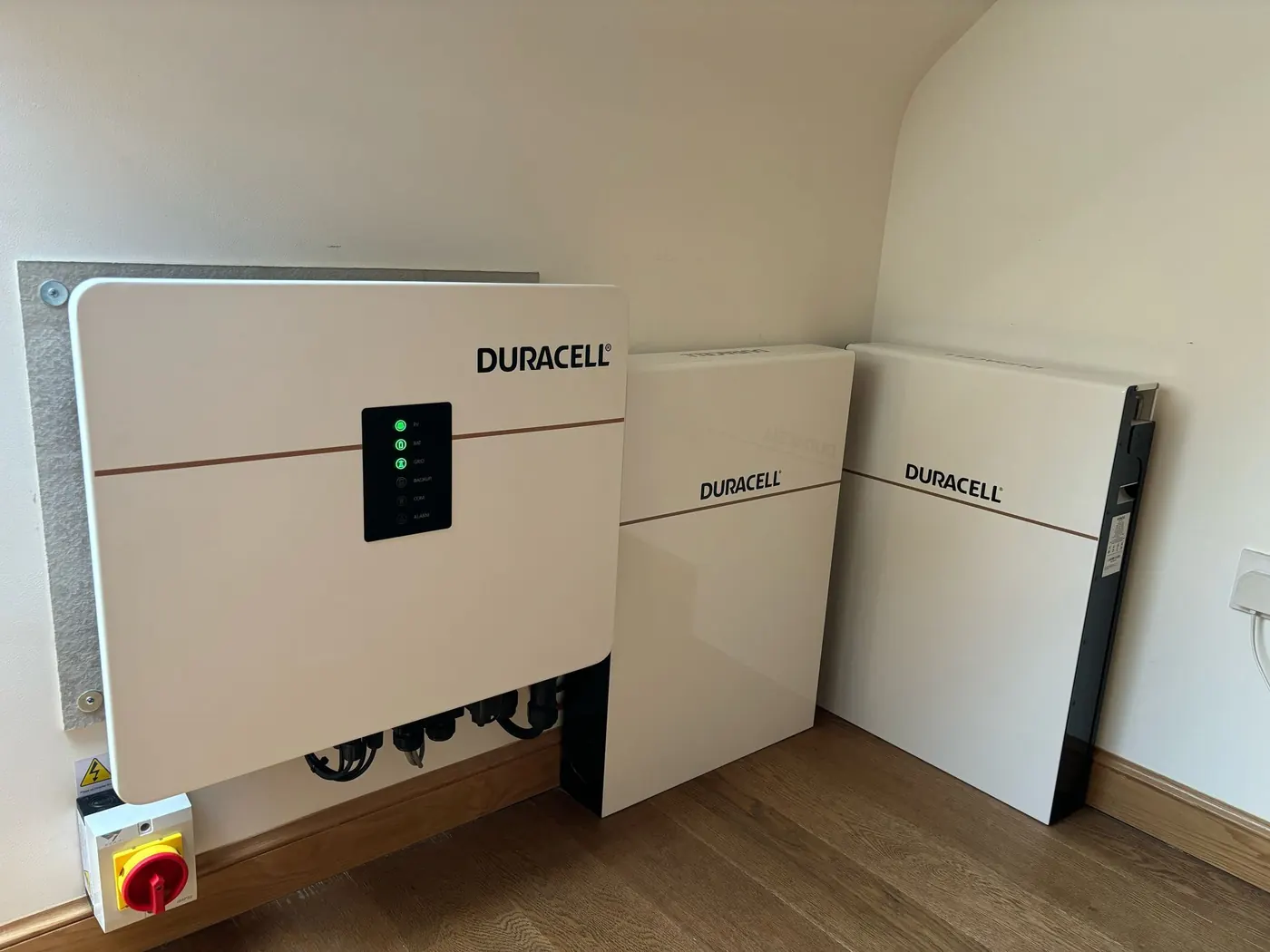 Duracell inverter and three battery storage modules installed against a domestic wall