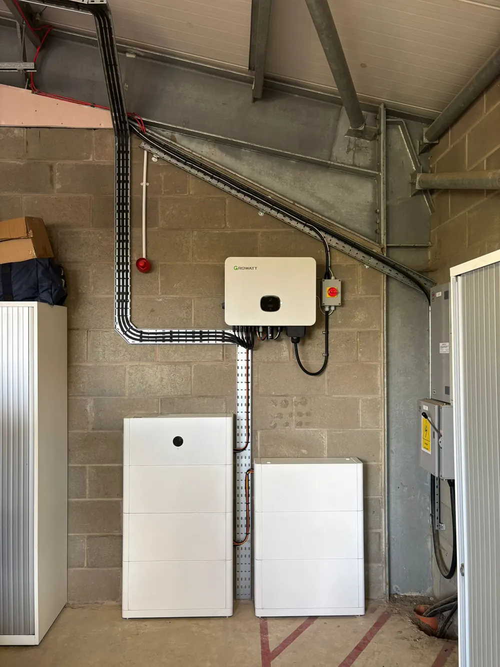 Growatt inverter and two stacked battery towers installed in a commercial plant room