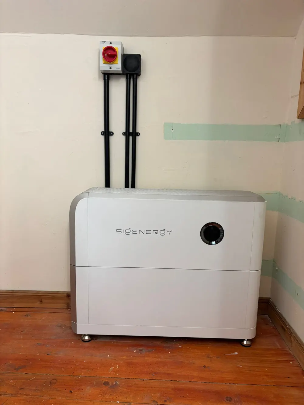 Sigenergy battery storage unit installed in a home with its DC isolator mounted above