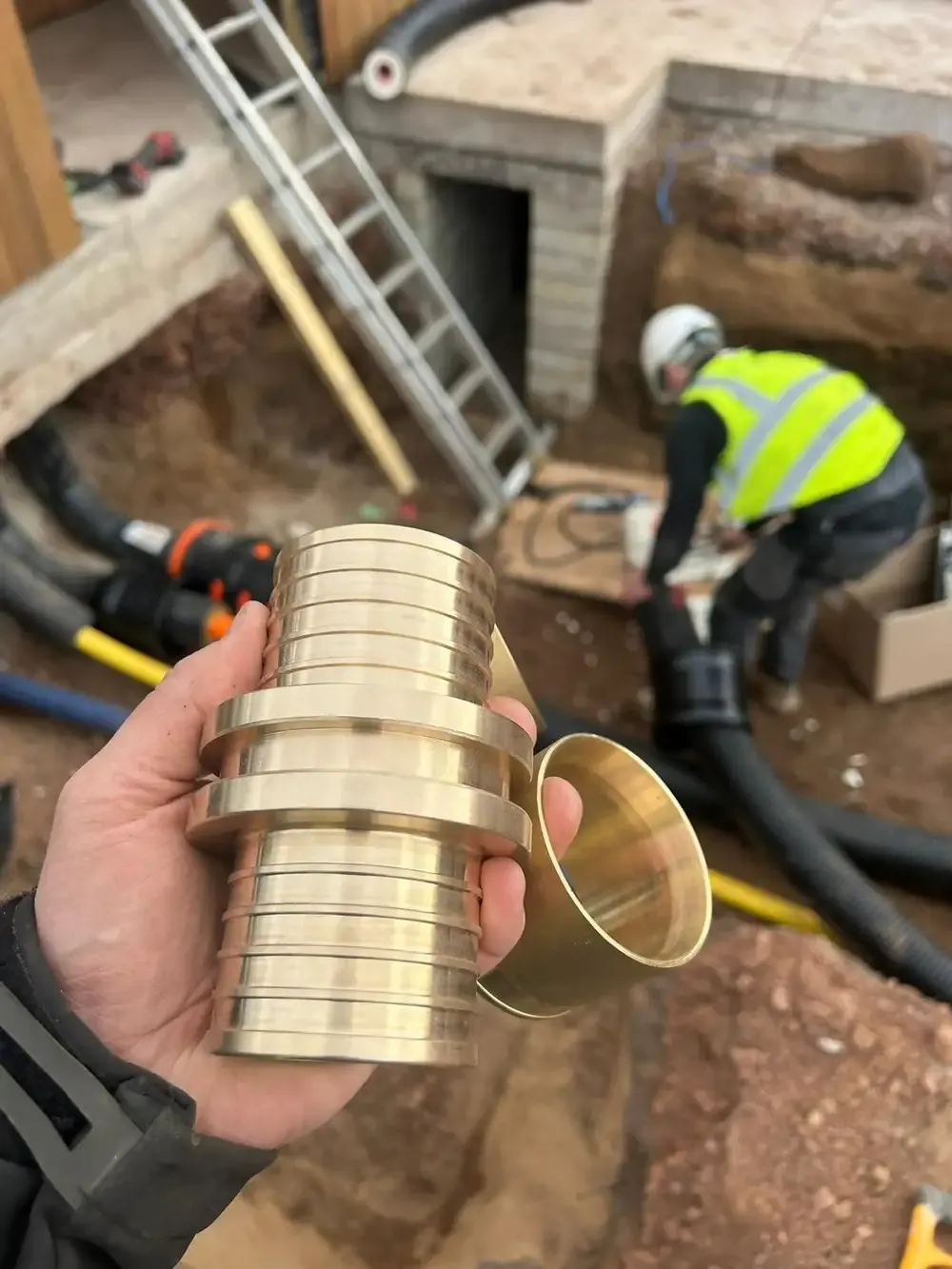 Brass pipe couplings held on site during a district heating installation
