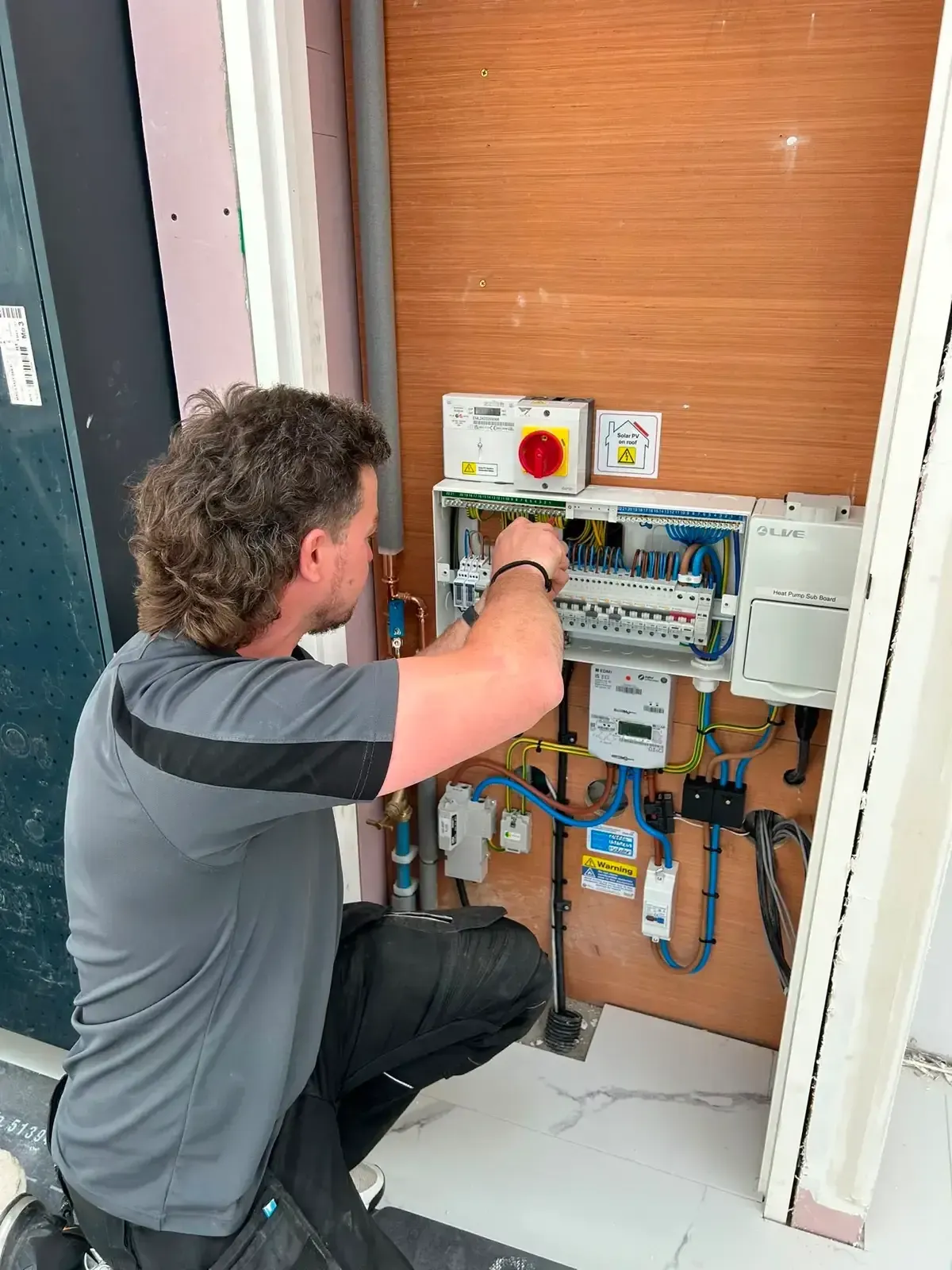 Consumer unit wired out and labelled, with the heat pump sub-board alongside