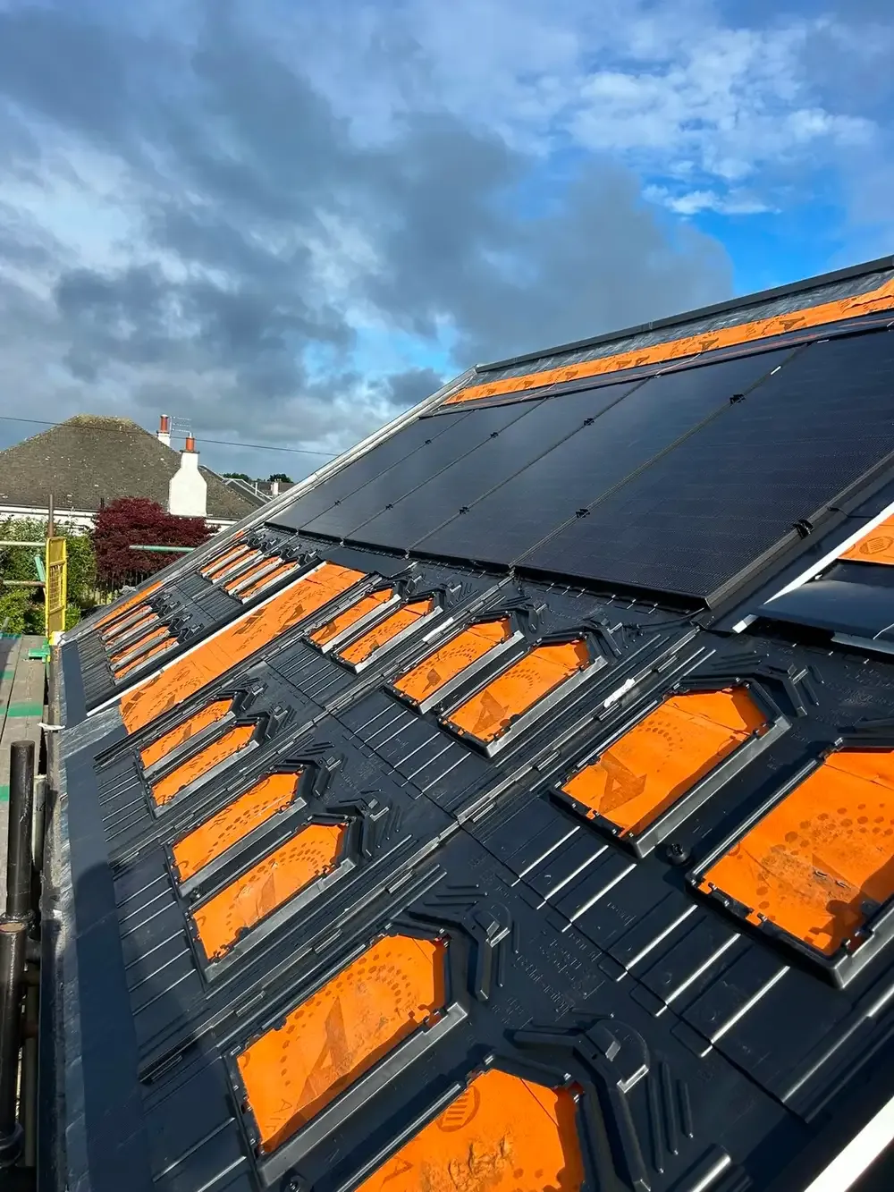 Solar panel mounting brackets being fitted to a slate roof mid-installation
