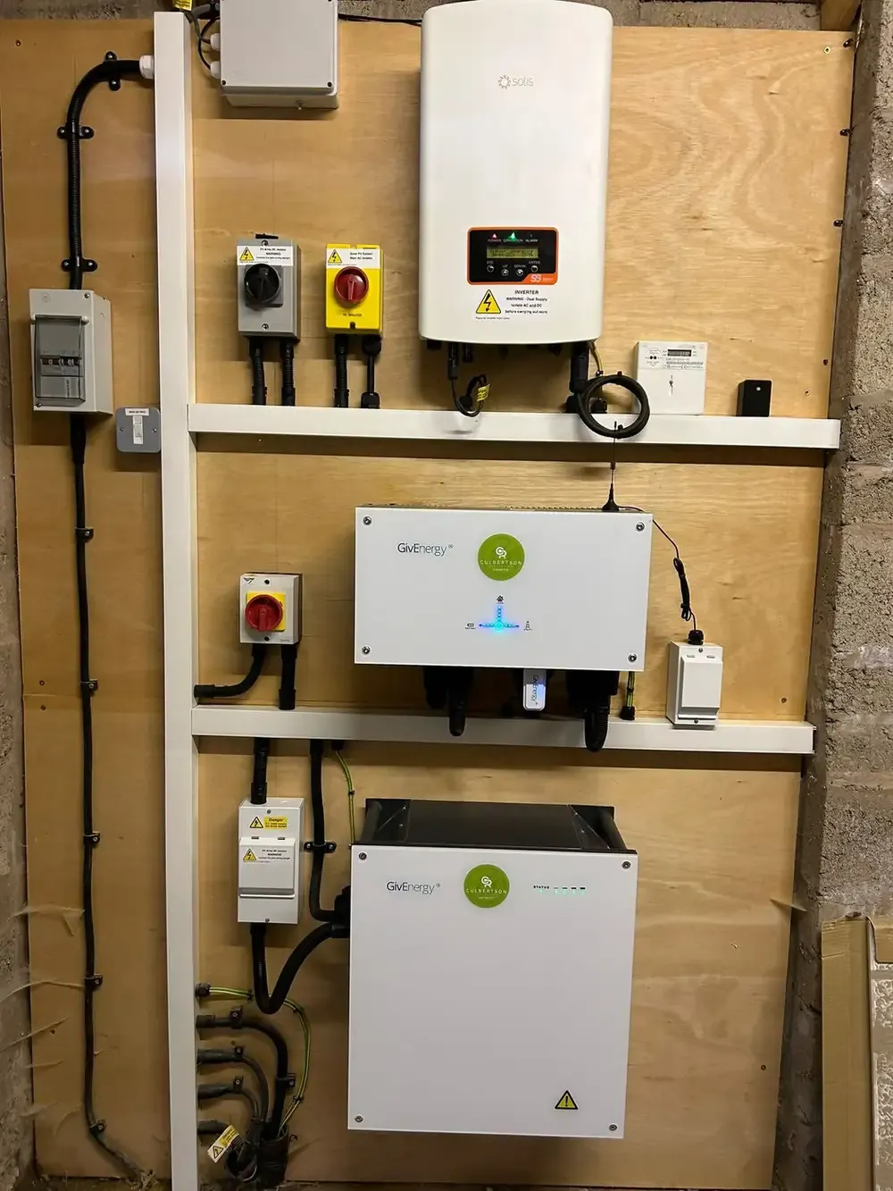 GivEnergy inverter and battery storage unit mounted in a plant room with isolators and metering