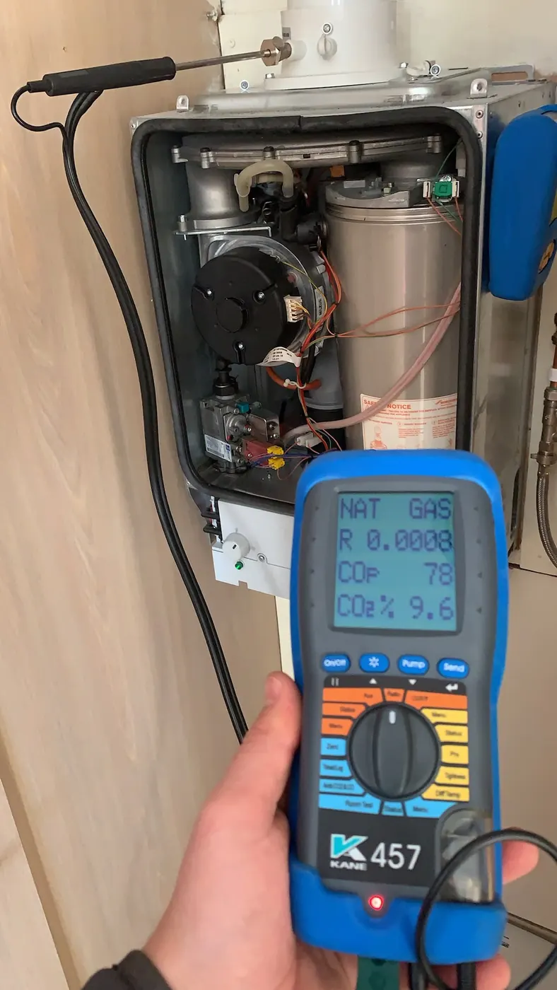 Gas Safe registered engineer taking a flue gas analyser reading during a CP12 check