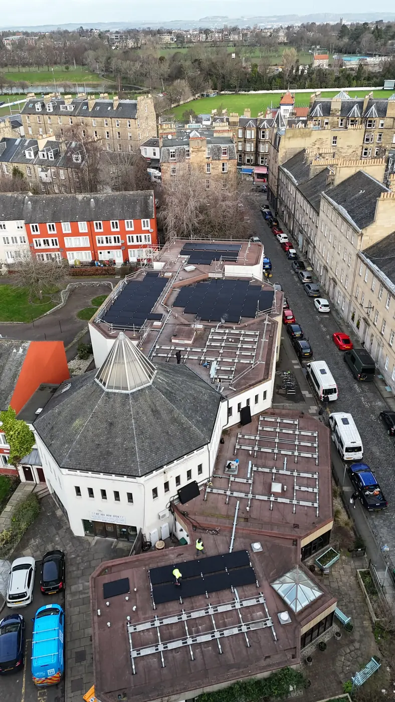 Aerial view of a commercial solar PV array and mounting rails installed across the roofs of a city-centre building in Edinburgh
